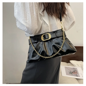 Détail du sac nuage plissé noir avec chaîne dorée et boucle porté par le mannequin