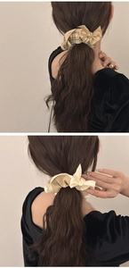 Detailed texture of khaki plaid and cream bow scrunchies on a ponytail hairstyle