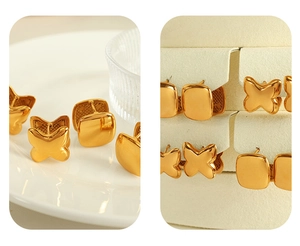 Detailed macro view of minimalist 18K gold butterfly and square earrings on display