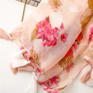 Close-up of pink floral scarf showing lightweight linen texture and white fringe tassels