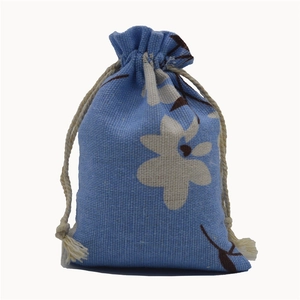 Detailed close-up of blue floral cotton linen drawstring pouch with cream white cord