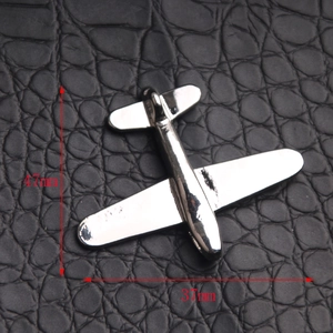Close-up of silver airplane pendant showing 47mm by 37mm dimensions on leather