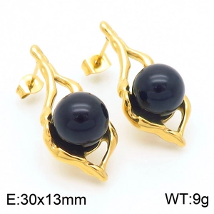 Detail shot of vintage gold earrings with black pearl and organic branch texture