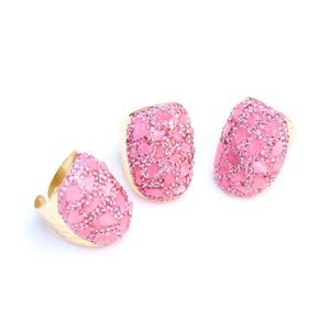 Detailansicht handgefertigter goldener Hammerringe mit unregelmäßigen rosa Kristallsteinen