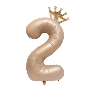 Detail of cream gold number 2 foil balloon with crown top for birthday party decor