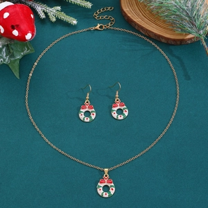 Flache Ansicht des Weihnachts-Schmucksets mit Goldkette auf dunkelgrünem Hintergrund