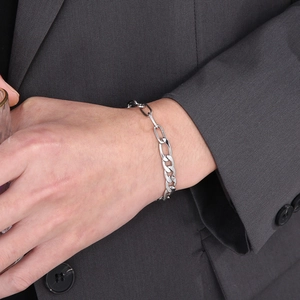 Silver stainless steel Figaro chain bracelet styled with a dark gray suit sleeve for men