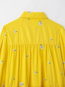 Detail of yellow French pastoral dress with delicate white floral embroidery on the back