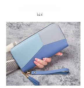 Detail view of a long zipper wallet in blue and grey PU leather with a decorative tassel