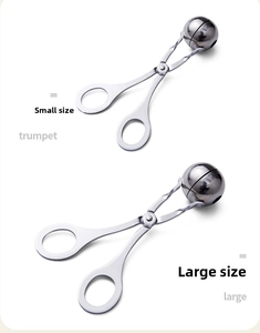 Close-up of small and large stainless steel meatball makers with polished metal finish