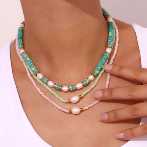Detail view of a 3-layer necklace with colorful beads and white freshwater pearls