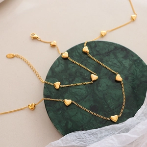 Colliers dorés avec pendentifs cœur sur marbre, détail en argent S925 certifié