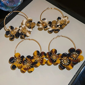 Macro view of leopard print fabric flower earrings with elegant gold metal hoop detail