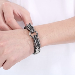 Détail d'un bracelet tête de dragon pour homme avec cuir tressé noir et métal poli