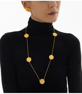 Nahaufnahme der goldenen Wabenhalskette und Ohrstecker am Model im minimalistischen Stil