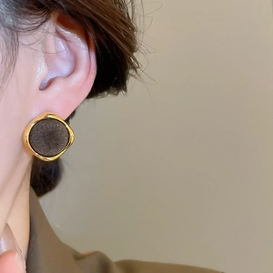 Model wearing vintage gold square earrings with black velvet inlay for an elegant look