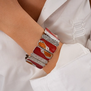 Detailed macro view of vintage geometric wide bracelet with red and orange enamel inlay