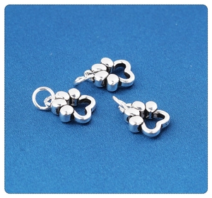 Macro shot of S925 sterling silver paw print pendants with hollow design and shiny finish