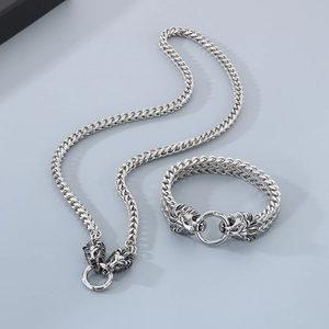 Detailed view of silver lion head necklace and bracelet set with dragon bone chain texture