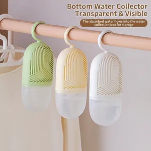 Hanging wardrobe dehumidifier bag with transparent collection tank in home closet setting