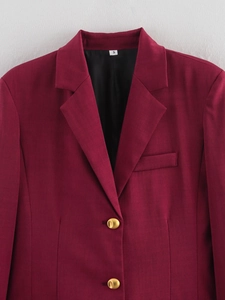 Detail of burgundy blazer with golden buttons and fine twill texture on plaid fabric