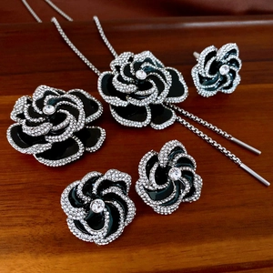 Detailed view of camellia jewelry set with black enamel and sparkling rhinestones