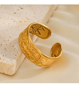 Detailed shot of vintage gold ring with geometric relief on stone and silk background