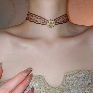 Close-up of vintage brown lace choker with sparkling diamond heart flower centerpiece