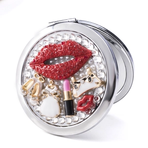 Portable metal round makeup mirror with red rhinestone lips and pearl embellishments