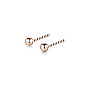 Macro shot of rose gold ball stud earrings with a high-polished mirror finish