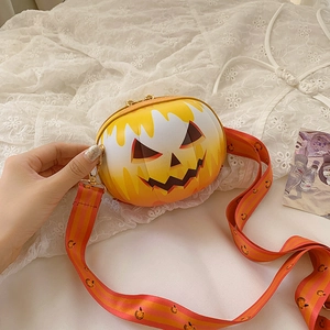 Detail view of pumpkin crossbody bag with jack-o'-lantern face and matching strap