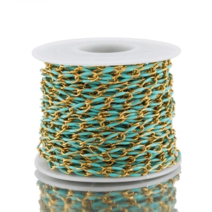 Macro detail of 3.7mm gold-plated stainless steel chain with cyan enamel on a white spool