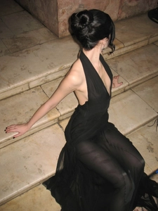 Chic black halter neck dress with sexy cut-outs and mesh skirt on marble steps