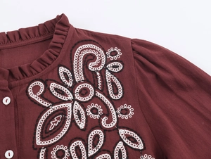 Dettaglio camicia bordeaux con ricamo floreale, bottoni bianchi e colletto a volant