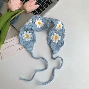 Close-up of handmade crochet light blue headband with white daisy floral details
