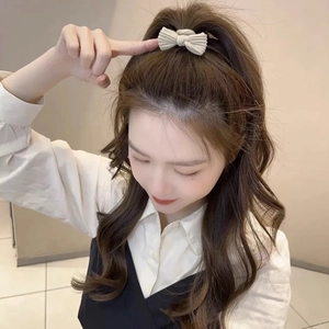 Detail of cream rib-knit bow hair tie showing high-elasticity texture on model