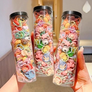 Close-up of three clear jars filled with colorful Y2K flower and bear hair accessories