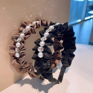 Detail of satin headbands with pearls and rhinestones in black and brown colors