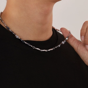 Close-up detail of titanium steel necklace with grey cubic and round hematite beads