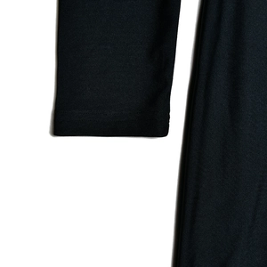 Gros plan sur le poignet en maille noire montrant la texture du tissu d'une robe longue