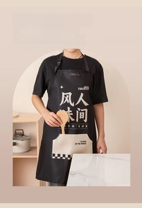 Close-up of waterproof black kitchen apron with large pocket and decorative text