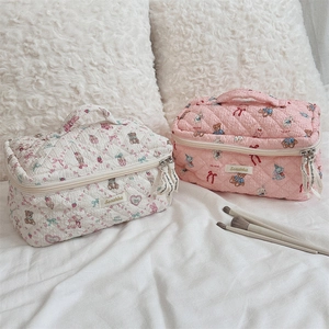 Detail of quilted cotton makeup bags featuring cute bear prints and durable dual zippers