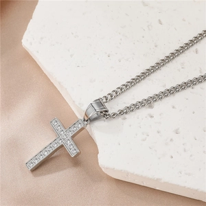 Vue détaillée du pendentif croix en acier titane argenté serti de pierres brillantes