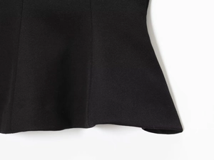 Detail shot of black fabric texture and ruffled hemline with professional tailoring