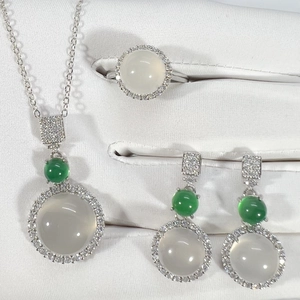 Detail of silver jewelry set with translucent white chalcedony and green accents