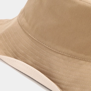 Detailed macro view of khaki cotton bucket hat featuring reinforced multi-row stitching