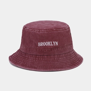 Détail de la broderie Brooklyn et des œillets métalliques sur un bob bordeaux