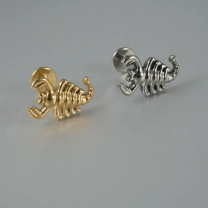 Vue détaillée des piercings labret scorpion en titane de couleur or et argent