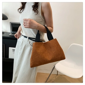 Vue détaillée du sac à main élégant en velours côtelé uni avec une texture douce et pratique.
