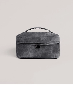 Detail of vintage canvas toiletry bag with washed texture, sturdy handle and dual zippers